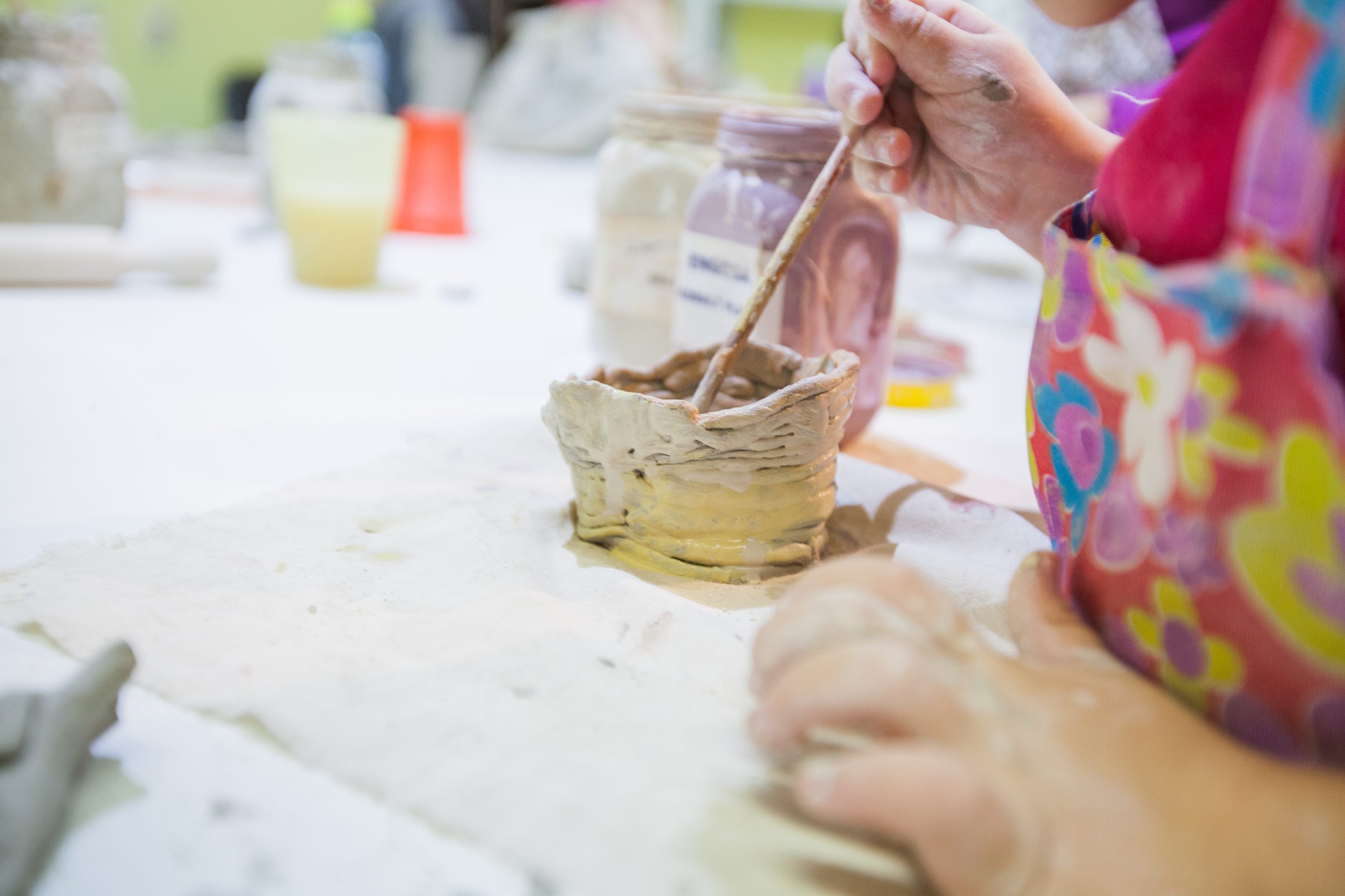 Closeup,Of,Childrens,Hands,Painting,With,Brush,Clay,Items,At